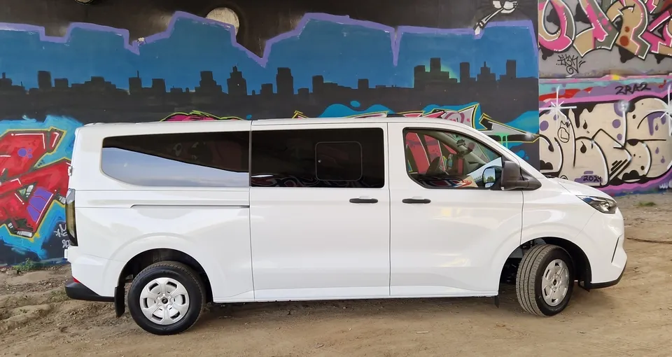 biały ford Transit Agatexu na tle graffiti